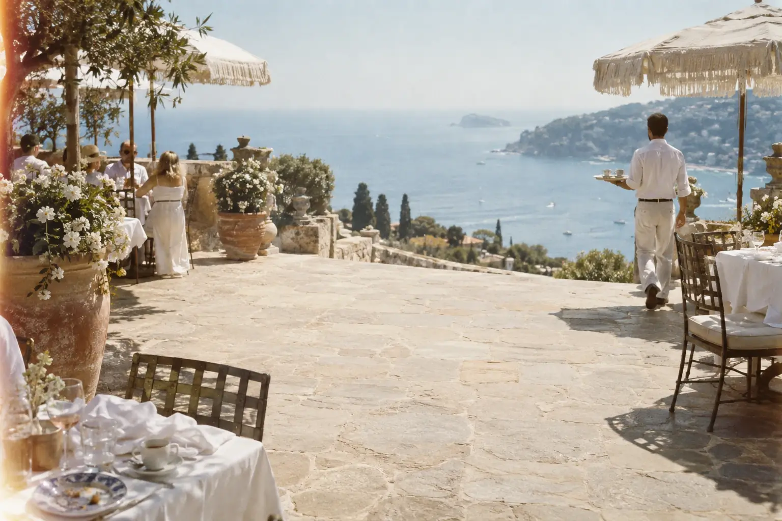 A sunlit hotel terrace overlooking the Mediterranean